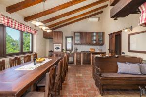 una gran cocina con una larga mesa de madera y sillas en Villa Clara by Villsy, en Motovun