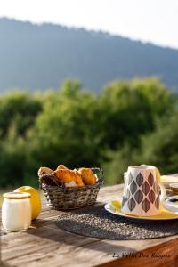 a table with a basket of pastries and a cup of coffee at La Villa Des Raspes - Séjour Spa - Adult Only in Viala-du-Tarn