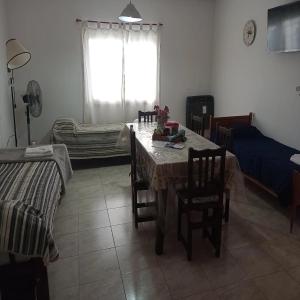 ein Esszimmer mit Tisch und Stühlen und einem Fenster in der Unterkunft Alquiler Temporario CF in San Carlos de Bolívar