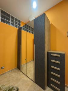 a dressing room with yellow walls and a mirror at La notte dei tempi in Scaletta Zanclea