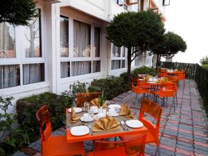 a row of orange tables and chairs in front of a building at Sinclairs Darjeeling in Darjeeling