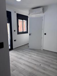 ein leeres Zimmer mit einer weißen Tür und Fenstern in der Unterkunft excelente estudio a 200 metros playa in Marbella
