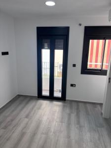 ein leeres Zimmer mit zwei Türen und Holzboden in der Unterkunft excelente estudio a 200 metros playa in Marbella