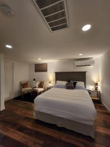 a bedroom with a large white bed and two chairs at HomeSmart: Cozy Charm Meets High-Tech in Prime Area in Seattle
