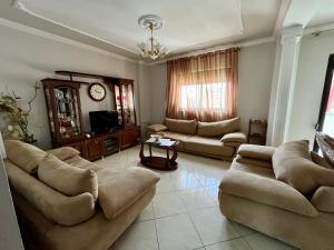 Una gran sala de estar con sofás y un televisor. en Era's apartment, en Durrës