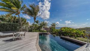 a villa with a swimming pool and palm trees at Enchanting Caribbean Honeymoon Haven in Pointe Milou