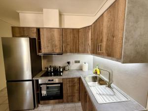 a kitchen with wooden cabinets and a stainless steel refrigerator at The Castle in Igoumenitsa