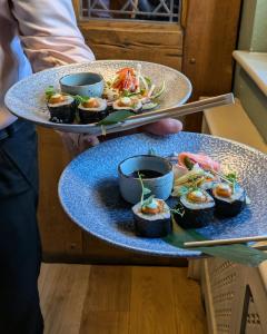 a person holding two plates with food on them at The Plough Inn & Restaurant in Congleton
