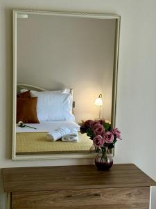 a bedroom with a large mirror on a table with flowers at The Castle in Igoumenitsa +16 photos