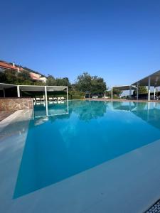 a large swimming pool with blue water at Villa Setharè in Salerno