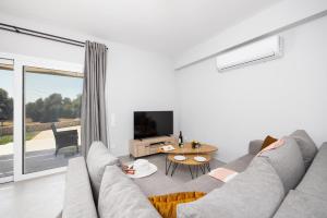 un soggiorno con un divano e una TV di Villa Tania Dio a Karavádhos
