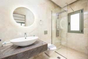 a bathroom with a sink and a glass shower at Villa Tania Ena in Karavádhos +10 photos