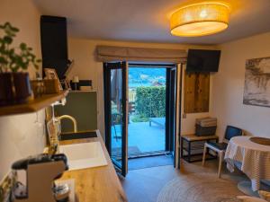 a living room with a door to a patio at Haus Kleinod in Bodensdorf