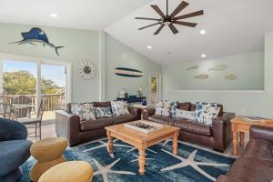a living room with leather couches and a table at Aloha Shores in Southern Shores