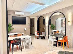 a dining room with tables and chairs and a tv at Choozme in Lukang