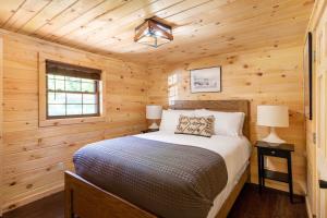 a bedroom with a bed in a log cabin at 2 Mi to Dtwn Spacious Gatlinburg Home with Hot Tub! in Gatlinburg