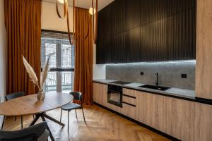 a kitchen with a table and a sink and a counter at Vidalis Suites in Cluj-Napoca