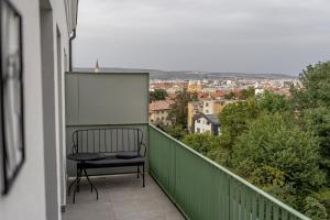 a chair on a balcony with a view of a city at Vidalis Suites in Cluj-Napoca