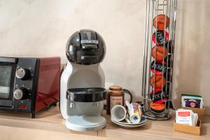 a coffee maker sitting on a counter next to a microwave at Bettí House vasca idromassaggio metro C Alessandrino - San Giovanni e trenino laziali-Termini -Bettí House in Rome