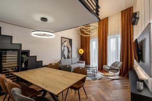 a living room with a table and chairs and a couch at Vidalis Suites in Cluj-Napoca