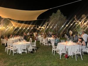 a group of people sitting at tables under a tent at B&B Medali in Vernole +62 photos
