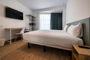 a hotel room with a large bed and a desk at Hotel Calella by Beatriz Hoteles in Calella