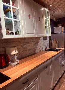 a kitchen with white cabinets and a wooden counter top at Żaroowka Slow House in Międzybrodzie Żywieckie