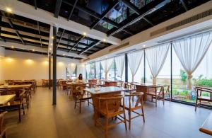 a restaurant with tables and chairs and large windows at Mare Nubium Resort in Zhangjiajie