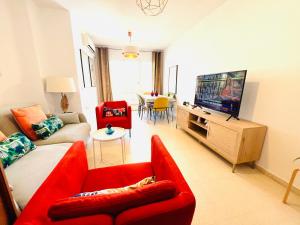 a living room with a red couch and a television at Apartamento Rincón, Ideal para familias in Cala del Moral
