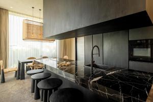 eine Küche mit einer Theke mit Spüle und Hockern in der Unterkunft Five Stories Villas By SUOM in Canggu