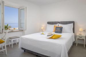 a bedroom with a large white bed with a window at Apartments Amfora 2 in Podgora
