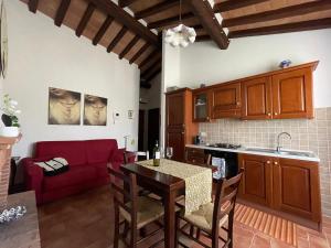 a kitchen and living room with a table and a red couch at Villa Kima tartufo in Toscella