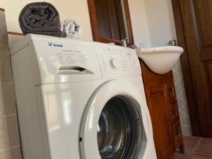 a white washing machine in a bathroom with a sink at Villa Kima tartufo in Toscella
