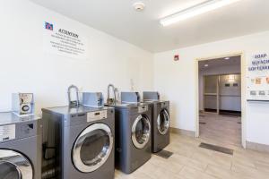 a laundry room with three washing machines in it at Motel 6-Roswell, NM in Roswell