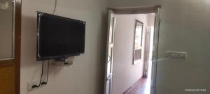 a flat screen tv hanging on a wall next to a door at Palms View Villa in Mount Ābu