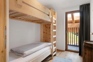 a wooden bunk bed in a room with a window at Prielerhof in Chienes