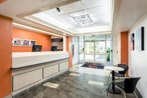 an office lobby with orange walls and a reception counter at Motel 6-Roswell, NM in Roswell