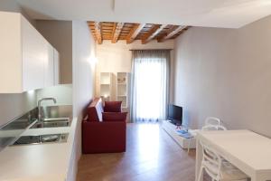 a living room with a red couch and a kitchen at Residenza Madonna Verona in Verona