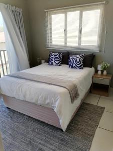 un grand lit dans une chambre avec une fenêtre dans l'établissement 46 at Mtwalume Holiday Resort, à Umtwalumi