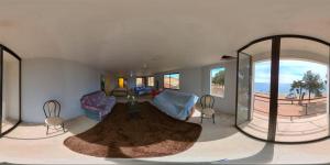 a living room with a couch and a table and some windows at Cabañas sumasamawi in La Playa Bejarano