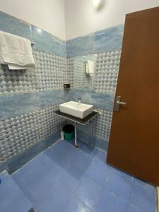 a bathroom with a sink and a blue floor at Kedar Villa Lansdowne- A complete private homestay in Lansdowne