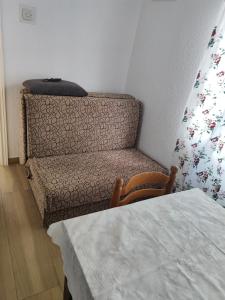 1 dormitorio con 1 cama y 1 silla con almohada en Apartmani Prestige, en Baška Voda