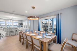 a dining room with a long table and chairs at Bela Vista in Nags Head +51 photos