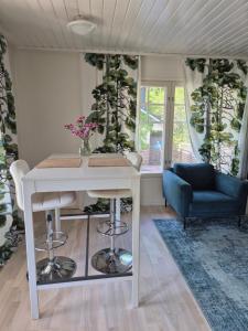 a living room with a white table and a couch at Villa Mosahiisi Charming Poolside Getaway in Helsinki
