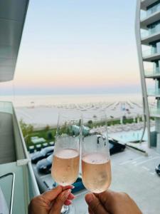 2 Personen mit Champagner auf dem Balkon in der Unterkunft White Sea Studio Premium in Mamaia Nord – Năvodari