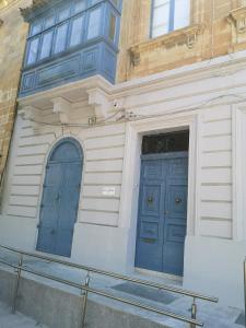 two blue doors on the side of a building at 17 Domus Mariae Town House in Senglea
