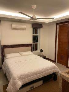 a bedroom with a bed with a ceiling fan at Luxuary 1 Bedroom Apartment Pool and Sea view in Dauin in Dauin