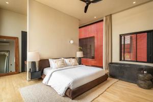 ein Schlafzimmer mit einem Bett und einem großen Fenster in der Unterkunft Five Stories Villas By SUOM in Canggu