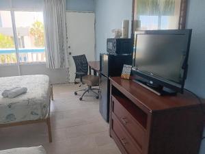 a living room with a television on a wooden dresser at Beach Side Hotel in Myrtle Beach
