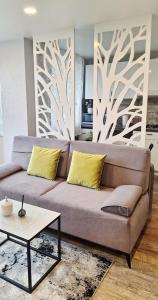 a living room with a couch and a table at Apartamentai su balkonu prie Akropolio Taikos pr 48 in Klaipėda
